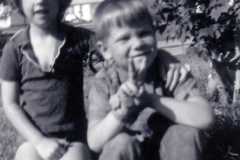 Teresa with neighborhood boy, Hanson, Mike Arnold photobombing behind the tree, 1971.