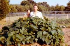 Joyce and Laban (kneeling) behind squash plant, Bexley garden, 1971.