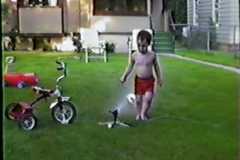 Dave Arnold playing with the sprinkler in back yard at Fourth Street home, July 1986.